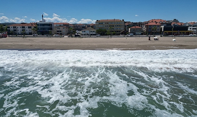 Dalgalı denize giremeyince, sahilde güneşlendiler