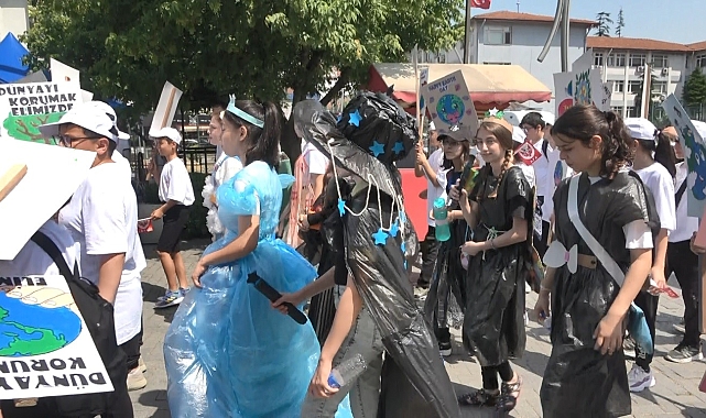 Sıcak havaya rağmen giydikleri çöp poşeti ile yürüyerek çevre mesajı verdi