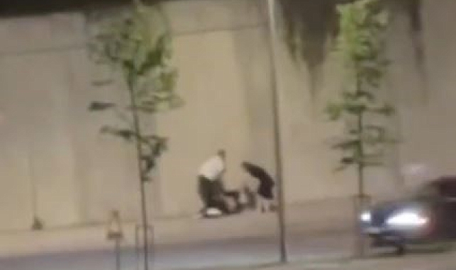 İki kişi kaldırıma oturmuş olan bir kadını saçından ve kollarından tutarak sürükledi