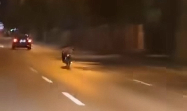 Motosiklet sürücüsü uzanarak trafikte seyrederek canını hiçe saydı