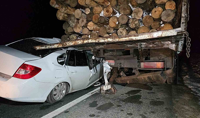 Otomobil, tomruk yüklü kamyonun altına girdi